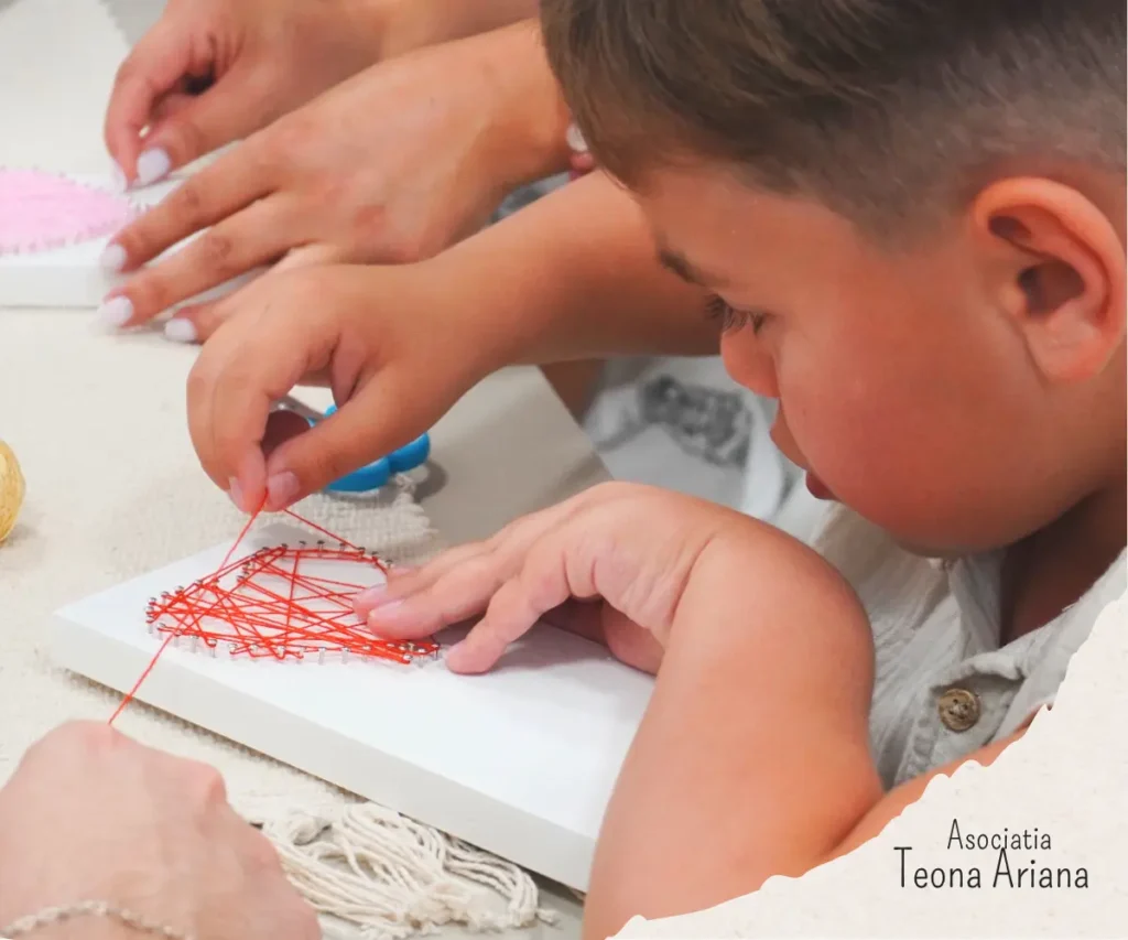Participant lucrând la un tablou string art cu inima în cadrul atelierului