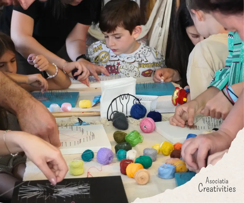 Participanti lucrând la tablouri string art în cadrul atelierului